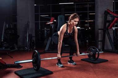 Genç güzel kadın ile egzersiz yaparak bar bir spor salonunda. Fitness merkezinde egzersiz yapıyor atletik kız.