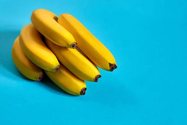Frische Bananen aus nächster Nähe auf hellblauem Hintergrund. flach lag. Sommerkonzept. — Stockfoto