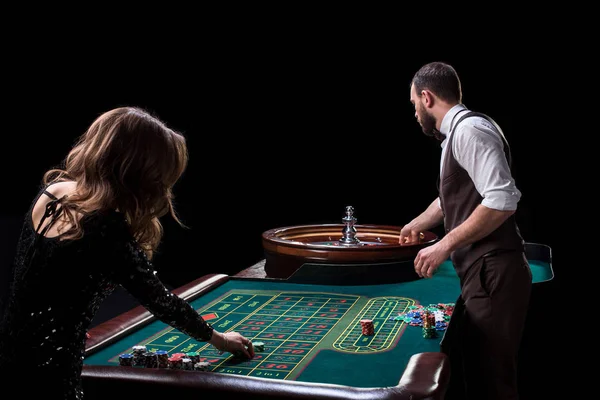 Bir tablo bir casinoda krupiye ve kadın oyuncu. C resmi — Stok fotoğraf