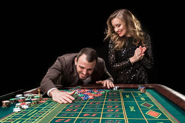 Mann und Frau spielen am Roulettetisch im Casino — Stockfoto