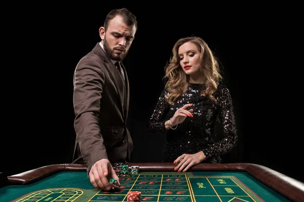 Hombre y mujer jugando en la mesa de ruleta en el casino — Foto de Stock