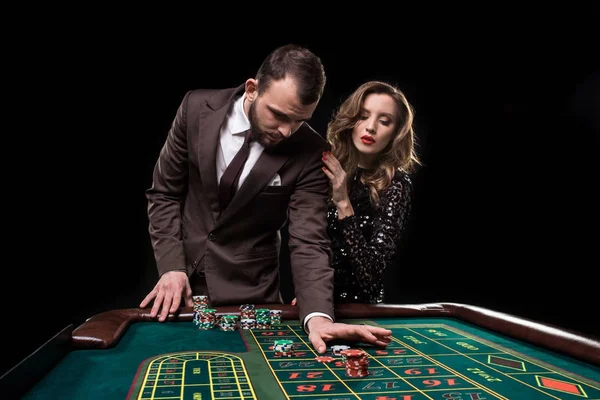 Férfi és nő játszik, a kaszinó rulett asztal — Stock Fotó