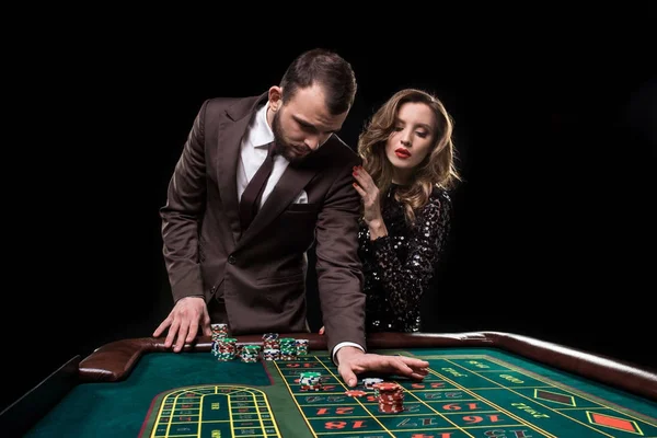 Homem e mulher jogando na mesa de roleta no cassino — Fotografia de Stock