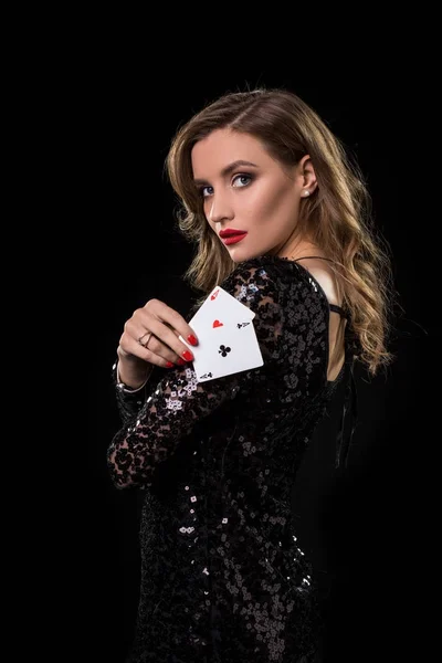 Молодая женщина держит игральные карты на черном фоне — стоковое фото