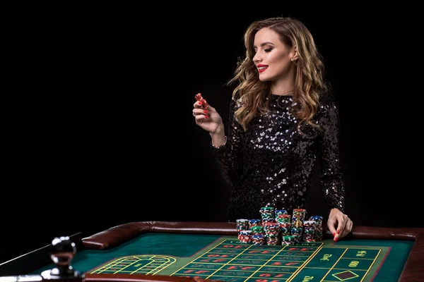 Woman playing in casino. Woman stakes piles of chips playing rou Stock Image