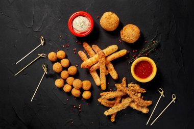 Siyah arka plan üzerine iki farklı soslar kızarmış aperatifler duracaksınız. Yakın çekim. Üstten Görünüm