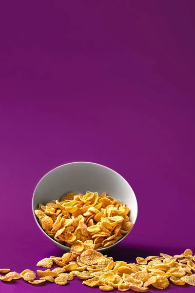 Ciotola con cornflakes sullo sfondo colorato — Foto Stock