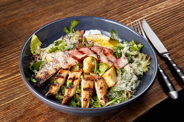 Kycklingsallad. Caesarsallad med kyckling. Caesarsallad med grillad kyckling på tallriken. Grillad kycklingbröst och fräsch sallad i plattan — Stockfoto