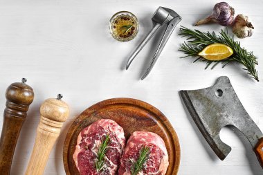 Baharat beyaz arka plan, üstten görünüm ahşap tahta ve mutfak balta üzerinde iki ham sığır eti biftek