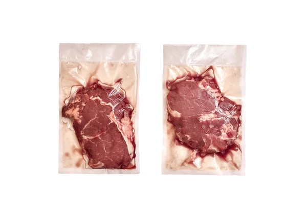 Відкрита упаковка з двох сирих яловичих стейків ізольована на білому тлі . — стокове фото