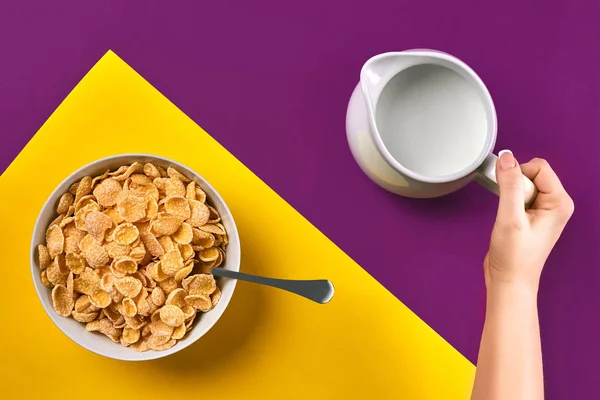 Comida, alimentación saludable, personas y concepto de dieta: primer plano de la mujer que come muesli con leche para el desayuno sobre fondo púrpura y amarillo — Foto de Stock