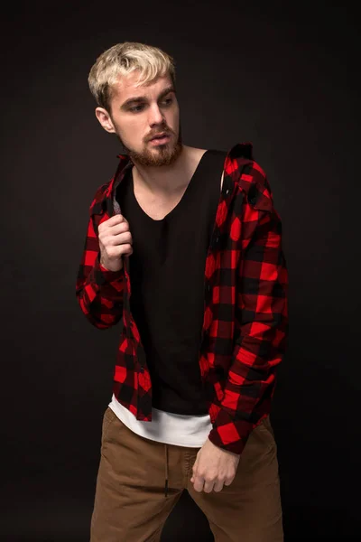 Imagen de un atractivo joven barbudo hipster vestido con camisa en una jaula aislada sobre fondo negro . —  Fotos de Stock