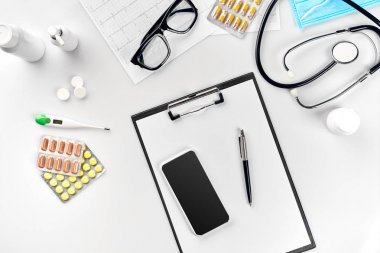 Stetoskop doktor ofisinde. Üstten Görünüm doktorlar Resepsiyon tablo, boş kağıt kalem ile Pano üzerinde. Uzay kopyalayın. Tasarımcılar boş