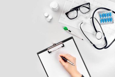 Doktor stetoskop ve defterini hastane Resepsiyon arka plan üzerinde çalışın. Üstten Görünüm