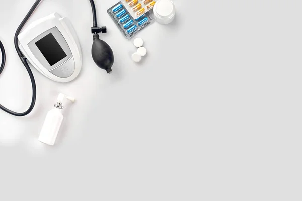 Elektronikus orvosi tonométer a vérnyomásmérés, a fehér asztal — Stock Fotó