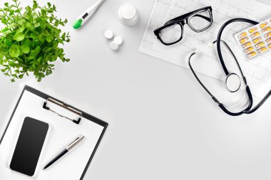 Stetoskop doktor ofisinde. Üstten Görünüm doktorlar Resepsiyon tablo, boş kağıt kalem ile Pano üzerinde. Uzay kopyalayın. Tasarımcılar boş
