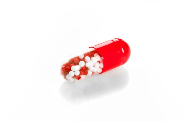 Macro red medical pill tablet with pellet, microgranules isolated on white — Stock Photo, Image