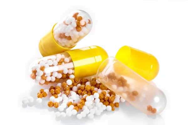 Comprimido de comprimido médico amarelo macro com pellet, microgrânulos isolados em branco — Fotografia de Stock