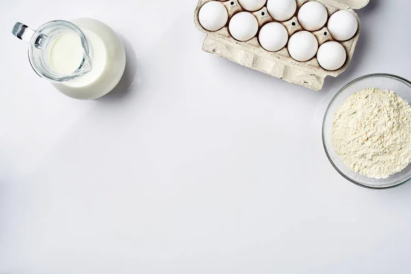 Vetemjöl i glas skålen, grädde i en glas burk, hönsägg - ingredienser för degen, ovanifrån — Stockfoto