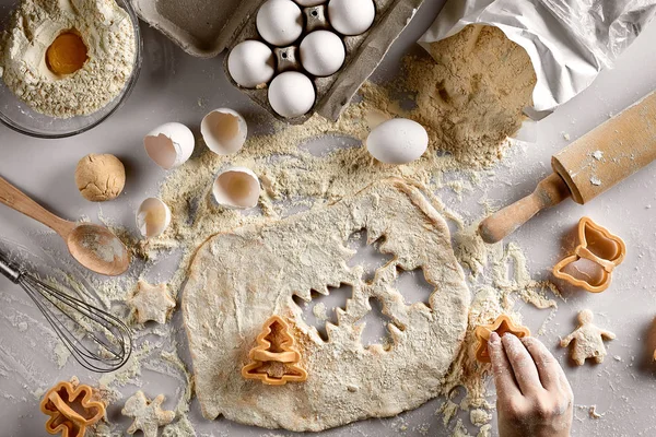 Preparazione al forno. Pasta cruda e taglierine per i biscotti natalizi su un tavolo bianco. Vista dall'alto . — Foto Stock