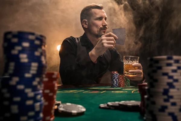 Vousatý muž pít whisky při hraní pokeru — Stock fotografie