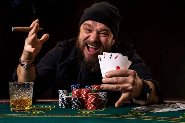 Skäggig man dricka whisky och röka en cigarr medan du spelar poker — Stockfoto