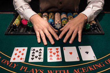 Close up of holdem dealer with playing cards and chips on green table clipart