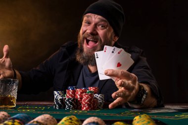 Sakallı adam puro ve poker masasında oturan ve çığlık izole üzerinde siyah cam