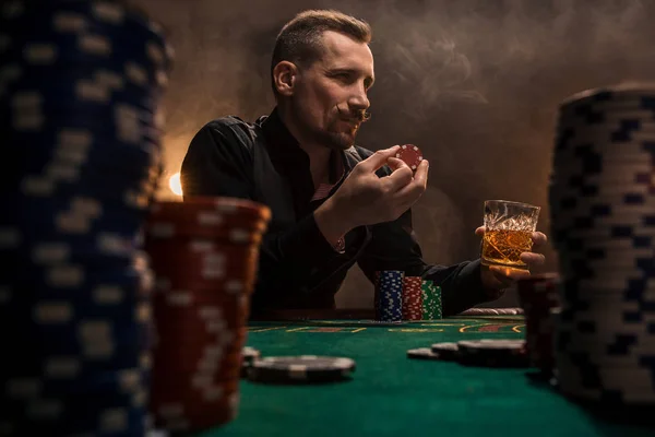 Junger schöner Mann sitzt hinter Pokertisch mit Karten und Chips — Stockfoto
