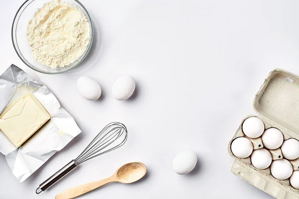 Beredning av degen. Ingredienser för degen - mjöl, smör, ägg och olika verktyg. På vit bakgrund. Ledigt utrymme för text. Ovanifrån — Stockfoto