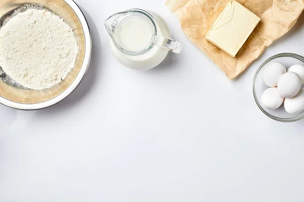 Preparação da massa. Uma medida da quantidade de ingredientes na receita. Ingredientes para a massa: farinha, ovos, leite, manteiga, creme. Vista superior, espaço para texto — Fotografia de Stock