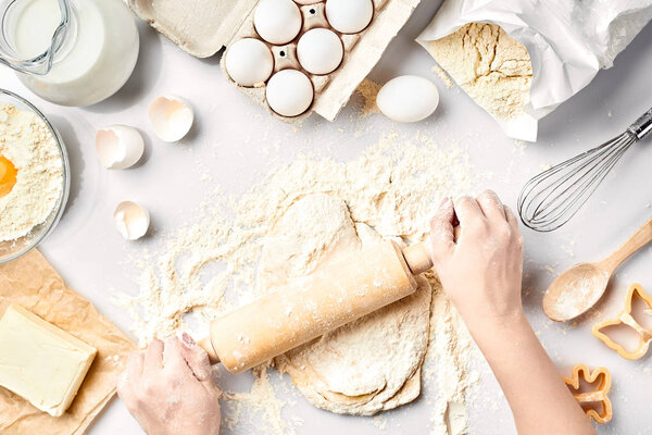 Подготовка к выпечке Сырое тесто и кусачки для праздничного печенья на белом столе. Вид сверху
.