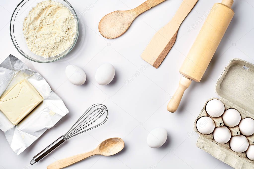 Preparation of the dough. Ingredients for the dough - flour, butter, eggs and various tools. On white background. Free space for text . Top view