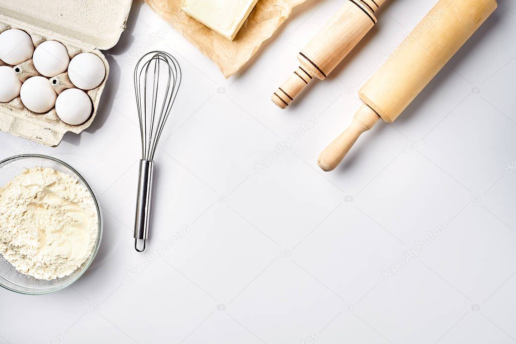 Preparation of the dough. Ingredients for the dough - flour, butter, eggs and various tools. On white background. Free space for text . Top view