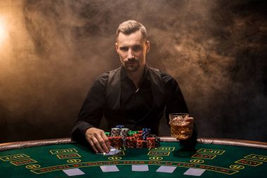 Poker oyuncusu. Casino oyun masasında genç bir adam. Adam kumar, kart oyunları. Kartları, cips, viski, Sigara, poker, kumar - kavram kumar kart oyunu,.