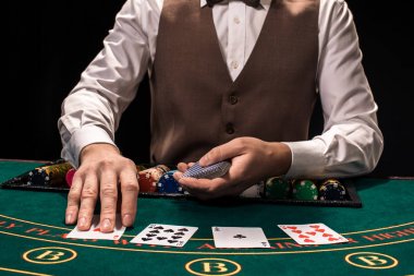 Holdem satıcısı iskambil kartları ve yeşil masada çipleri ile yakın çekim