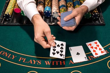 Holdem satıcısı iskambil kartları ve yeşil masada çipleri ile yakın çekim