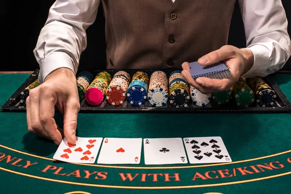 Close up de revendedor holdem com cartas de baralho e fichas na mesa verde — Fotografia de Stock