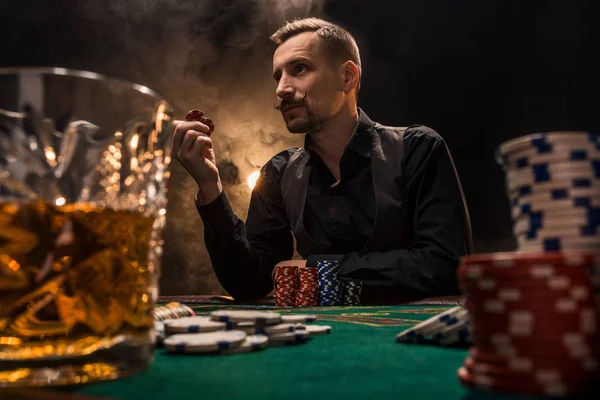 Mann pokert mit Zigarre und Whiskey. ein Mann gewinnt alle Chips auf dem Tisch mit dickem Zigarettenrauch. — Stockfoto