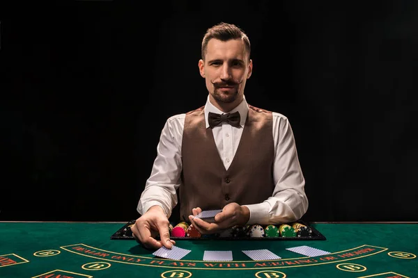 Croupier detrás de la mesa de juego en un casino . — Foto de Stock