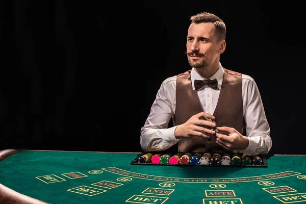 Croupier hinter Spieltisch im Casino. — Stockfoto