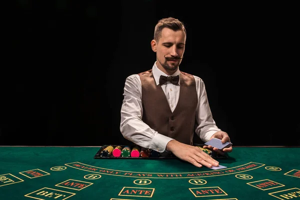 Croupier hinter Spieltisch im Casino. — Stockfoto