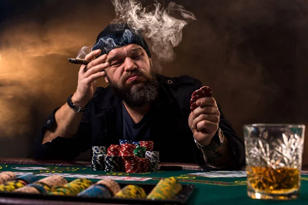 Ember játszik pókert, a whisky és egy szivar. Egy ember, megnyerte a chipek, az asztalra és sűrű cigarettafüst. — Stock Fotó