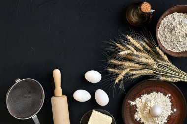 Siyah mutfak masasında makarna pişirme malzemeleri. Metnin için alanı olan en üstteki görünüm