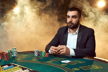 Oyun masada oturan iş elbiseli bir adam. Erkek oyuncu. Tutku, kartları, cips, alkol, kumar, casino - zar, o erkek eğlence 's.