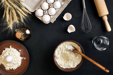 Siyah mutfak masasında makarna pişirme malzemeleri. Metnin için alanı olan en üstteki görünüm