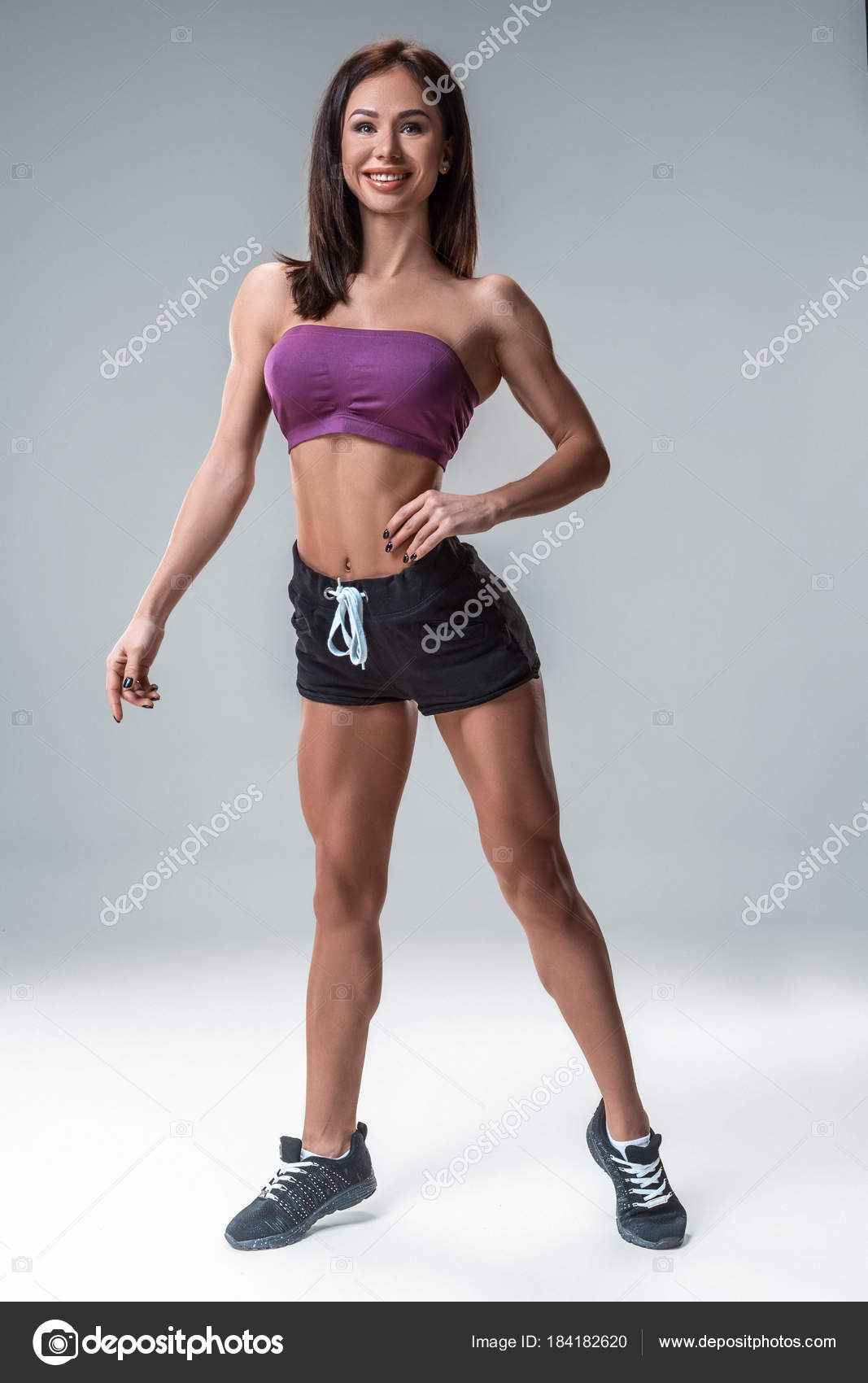 Perfect Fitness Body of Beautiful Woman. Fitness Instructor in Sports  Clothing. Female Model with Fit Muscular and Slim Body in Sportswear doing  Workout. Young Fit Girl Lifting Dumbbells. Stock Photo