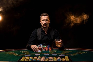 Poker oyuncusu. Casino oyun masasında genç bir adam. Adam kumar, kart oyunları. Kartları, cips, viski, Sigara, poker, kumar - kavram kumar kart oyunu,.