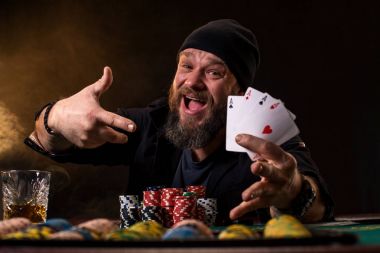 Sakallı adam puro ve poker masasında oturan ve çığlık izole üzerinde siyah cam