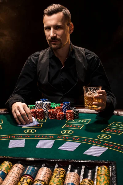Pokerspieler. Junger Mann im Casino am Spieltisch. Mann Glücksspiel, Kartenspiele. Karten, Chips, Whiskey, Zigaretten, Poker, Kartenspiel, Glücksspiel - Spielkonzept. — Stockfoto